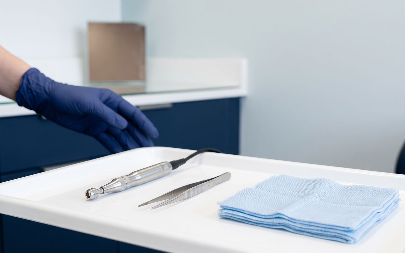 Strumenti per trapianto senza rasatura con micro-punch e pinzette su vassoio sterile